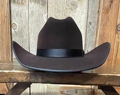 Expertly crafted with Serratelli's 8X fur felt, this Cowboy Hat features a luxurious cherry velvet finish and a sturdy 6 line cattleman hat band. Its classic design includes a black bound edge and a 4 5/16" front crease on the crown. With a 4 1/4" brim and genuine leather sweat band, this Long Oval hat offers both style and comfort. Serratelli 8X fur felt hat Cherry Velvet Cattleman 6 line hat band Black bound edge 4 5/16" front crease on crown 4 1/4" Brim Long Oval Genuine leather sweat band Cattleman Hat, Felt Cowboy Hat, Custom Crown, Felt Cowboy Hats, Straw Cowboy Hat, Sweat Band, Bull Riders, Western Hats, Velvet Color