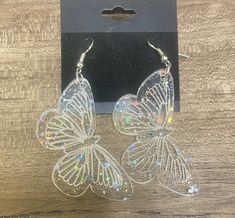 Get ready to spread your wings with these enchanting sparkly butterfly earrings! Dangle from your ears with these charming, crystal-like acrylic pieces, expertly crafted to catch the light and shimmer in the sun. The delicate steel hooks and jump rings add a touch of durability and ease of wear, while the soft rubber backs ensure a comfortable fit. These earrings are perfect for anyone who loves a little bit of whimsy and a lot of sparkle. Whether you're dressing up or dressing down, these sweet butterflies will add a touch of magic to your outfit. So why not treat yourself to a pair? You deserve to spread your wings and shine! Butterfly Party Earrings With Ear Wire, Hypoallergenic Butterfly Earrings For Party, Sparkly Butterfly, Butterfly Dangle Earrings, Butterfly Earrings, Etsy Earrings Dangle, Earrings Dangle, Soft Rubber, Jump Rings