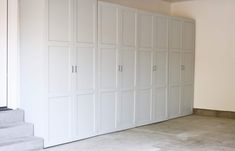 an empty room with white closets and steps leading up to the second floor area