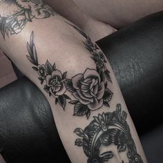 a black and white photo of a woman's arm with roses on it