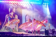 two women are performing on stage with umbrellas