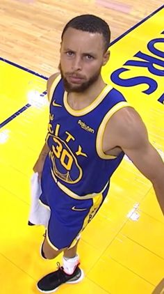 a basketball player standing on the court with his hands in his pockets and looking at the camera