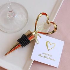 there is a wine glass with a cork on it and a card in the shape of a heart