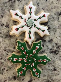 three decorated christmas cookies sitting on top of a marble countertop next to each other