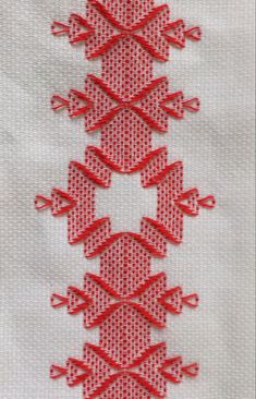 the red thread is stitched together to form an intricate pattern on white fabric,