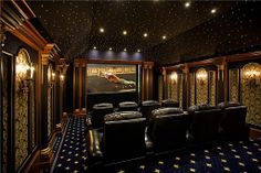 a home theater with black leather seats and stars on the ceiling