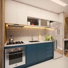 a kitchen with blue and white cabinets, an oven, sink and microwave in it