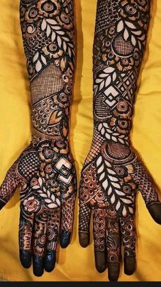 two hands with henna tattoos on them