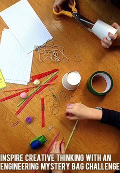 a child is doing crafts with pencils and paper on the table next to them