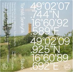 a poster with numbers and symbols on it in the middle of a field near a tree