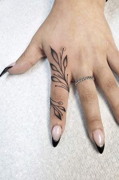 a woman's hand with a flower tattoo on it