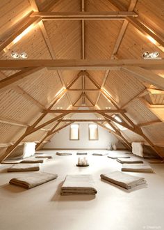 an empty room with wooden beams and white carpet