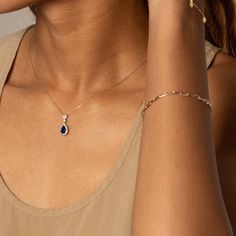 Make a statement with a teardrop-shaped sapphire pendant surrounded by a white sapphire halo. Crafted from solid 10k gold and 925 sterling silver in a two-tone style, it features a lab-created blue sapphire of 1.28 ct and a lab-created white sapphire halo of 0.38 ct.Pendant only, chain sold separately Blue Teardrop Pendant Jewelry With Diamond Accents, Blue Teardrop Pendant With Diamond Accents, Blue Teardrop Jewelry With Diamond Accents, Blue Teardrop-shaped Jewelry With Diamond Accents, White Gold Sapphire Teardrop Pendant Jewelry, Sapphire Diamond Drop Jewelry, Fine Jewelry Sapphire Teardrop Pendant, Sapphire Teardrop Pendant Fine Jewelry, Teardrop Sapphire Jewelry With Diamond Cut