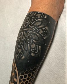 a man's arm with an intricate black and white tattoo design on the arm