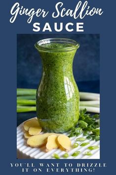 a green sauce in a glass jar on top of a plate next to some vegetables