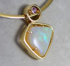 A lovely opal from Andamooka Australia is accented with a pink sapphire set in 14k yellow gold pendant. The Andamooka opal measures 19.5 x 24mm wide and weighs 13.94 carats The pink Sapphire from Thailand measures 3.5mm and weighs .25 carats The metal is 14k yellow gold and the pendant weighs 8.19 grams Jewelry from Stowe Gems arrives beautifully packaged in a gift box. If you have any questions about this piece or if we can help you with any of our other products please feel free to contact us. Stowe Vt, Pink Sapphire Pendant, Andamooka Opal, Indicolite Tourmaline, Special Necklace, Dainty Pendant, Tourmaline Necklace, Sapphire Pendant, Yellow Gold Pendants