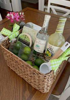 a wicker basket filled with alcohol bottles on top of a wooden table