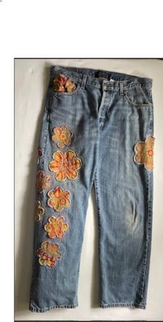 a pair of jeans with embroidered flowers on them