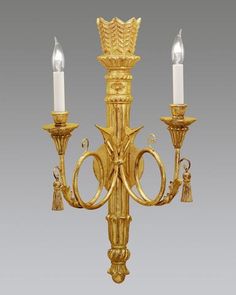 a golden chandelier with two candles on it's sides and one light in the middle