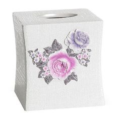 a white tissue box with pink and purple flowers on the front, sitting on a white surface