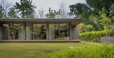 a modern house in the middle of a lush green yard