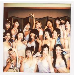 a group of young women posing for a photo in front of a mirror with their arms up