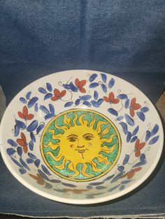 a decorative plate with the sun painted on it