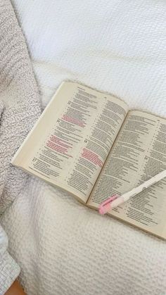 an open book laying on top of a bed