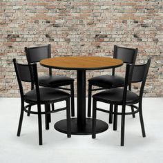 a table and four chairs in front of a brick wall with a black chair next to it