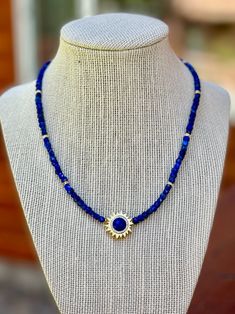 Dainty yet colorful 4mm square shaped lapis beads exhibiting shades of deep azure blue are interspersed with cz spacers to form this 16 inch long necklace. A 2 inch long gold chain gives you to option to lengthen the necklace to suit your needs. A bright blue lapis gemstone encircled by bright cz's is set in a gold sun shaped pendant. What a great look to finish off your summer outfits. All jewelry is sent to you packaged in a gift box that is tied off with ribbon and a charm. Colorful Lapis Lazuli Beaded Necklaces As Gifts, Lapis Lazuli Beaded Necklaces With Large Beads As Gift, Blue Lapis Lazuli Necklace With Spacer Beads, Lapis Lazuli Pendant Beaded Necklace As Gift, Colorful Beads Lapis Lazuli Necklace Gift, Lapis Lazuli Beaded Necklace With Large Beads For Gift, Gold Lapis Lazuli Necklace With Faceted Beads, Gold Lapis Lazuli Faceted Beads Necklace, Coin Pearl Necklace