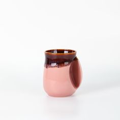 a pink and brown vase sitting on top of a white table