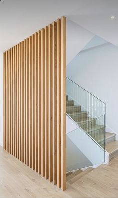 a staircase with wooden slats and glass railing