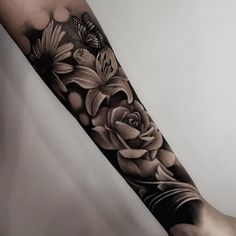 a black and white flower tattoo on the arm