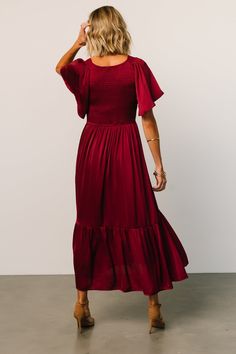 Beautiful deep wine color Soft satin-like material Rounded V neckline Smocked bodice with flutter sleeves Mid length midi style with semi pleated ruffle hem Lined from waist down Bump friendly 100% Polyester Trina is 5'6, cup size 32C, size 2 and is wearing size S Deep Wine Color, Staple Dress, Baltic Born, Wine Color, Pretty Dress, Cup Size, Flutter Sleeves, Black Midi Dress, Dressed Down