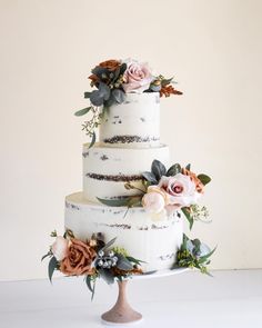 a three tiered cake with flowers on top