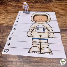 a spaceman cut out on top of a piece of paper next to a toy