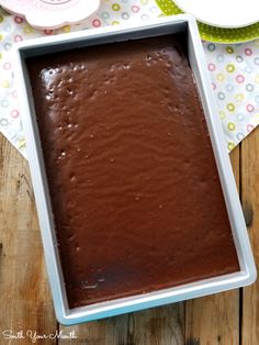 a pan filled with chocolate cake sitting on top of a wooden table