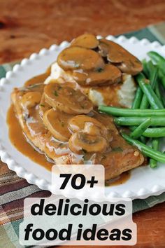 a white plate topped with meat covered in mushroom gravy and mashed potatoes