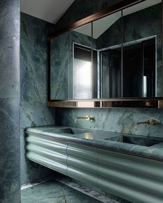 a bathroom with marble counter tops and mirrors