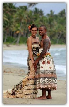 two people are standing on the beach together