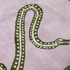 a green and white snake on a pink blanket