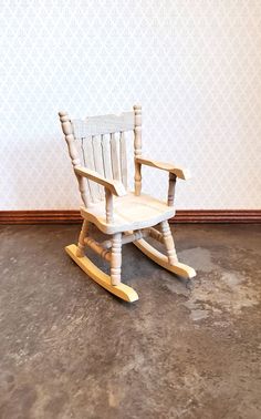 a wooden rocking chair sitting on top of a floor