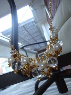 This Cluster Necklace created by Jewelry By Luet and Co is made of white glass pearls, clear glass and acrylic beads, gold plated:  chain, beads and findings.  This necklace measures 22 1/4 inches in length.View more chain necklaces:  http://www.etsy.com/shop/cdjali?section_id=10221957[N-1] Gold Jewelry With Pearl Charm And Crystal, Gold Crystal Necklace With Pearl Drop, Gold Beaded Chain Bridal Necklace For Party, Gold Bridal Necklace With Beaded Chain For Party, Gold Pearl Necklaces With Dangling Beads, Wedding Gold Metal Beaded Necklaces, Gold Metal Beaded Necklace For Wedding, Wedding Costume Jewelry Beaded Necklace, Gold Pearl Jewelry With Dangling Beads