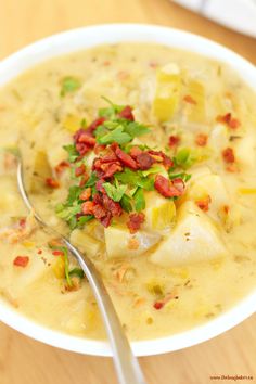 a white bowl filled with potato soup and garnished with chopped green onions on top