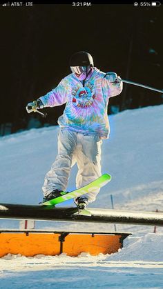 a man riding skis down the side of a snow covered slope on top of a rail