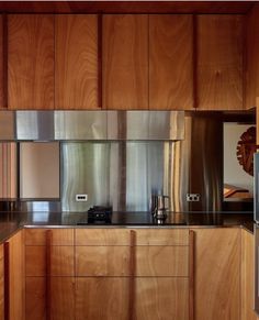 a kitchen with wooden cabinets and stainless steel appliances on the counter top, along with an oven