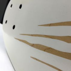 a close up view of the side of a white vase with brown lines on it