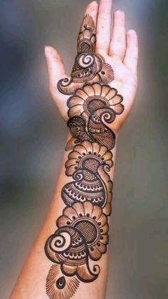 a woman's hand with henna tattoos on it