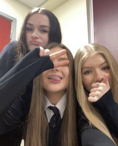 three young women are posing for the camera