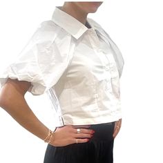 A sleek cotton poplin top with a tapered button up front and bubble sleeves. Its slightly cropped length and boxy fit make it a versatile piece for any occasion. Elevate your wardrobe with this fashion-forward must-have. Slightly cropped Button up closure Length: 17.5" 100% cotton Hand wash Dressy Earrings, Cotton Poplin Top, Person Icon, Cotton Crop Top, Poplin Top, Top Handbags, Bubble Sleeve, Bag Icon, Dress Hats